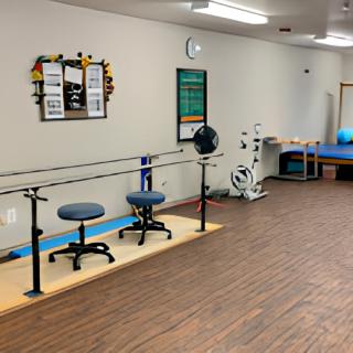 A physical therapy room equipped with parallel bars and exercise equipment.