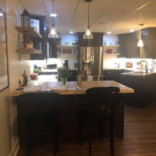 A cozy kitchen with a central island and pendant lights.