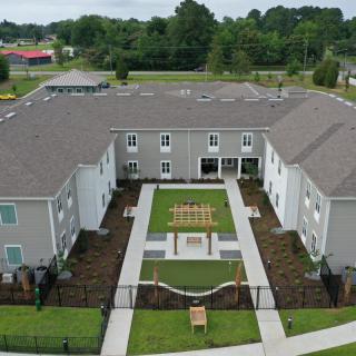A modern residential building with a landscaped courtyard, captured from an aerial perspective.