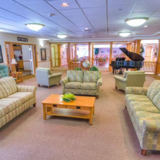 A spacious lounge area with comfortable seating and a piano.