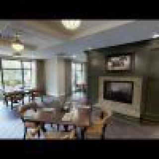 A modern dining room with a fireplace and large windows.