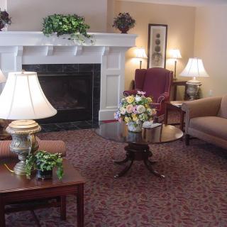 A cozy living room with a fireplace, comfortable seating, and elegant lighting.