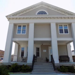 A classical-style residential building featuring prominent columns and a welcoming front porch.