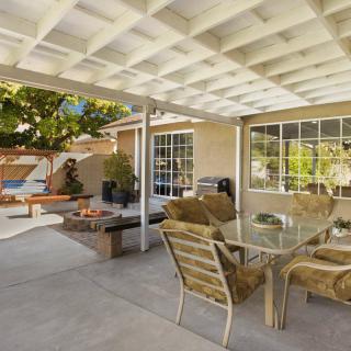A spacious outdoor patio with a glass table and chairs, perfect for relaxation.