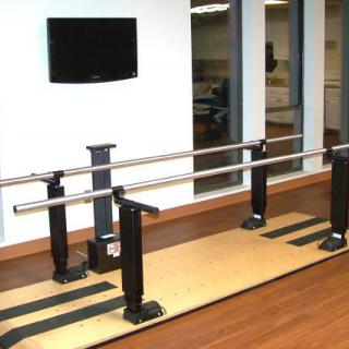 A pair of parallel bars used for physical rehabilitation and exercise in a therapeutic setting.