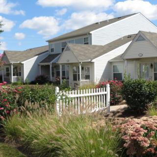 A suburban house with a well-maintained garden and white picket fence.