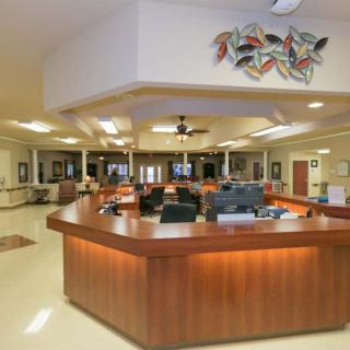 A spacious office lobby with a central reception desk and modern decor.