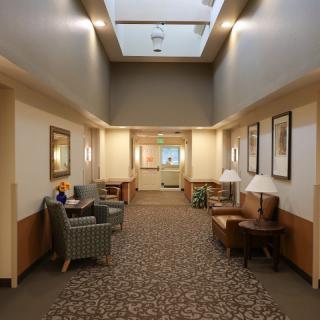A well-lit hallway interior with seating and decorative elements.