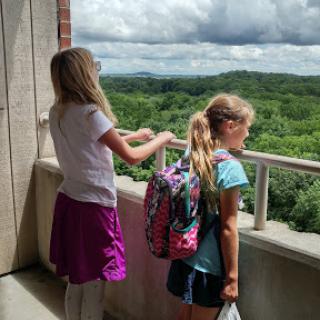 Two children enjoying a scenic view from a balcony.