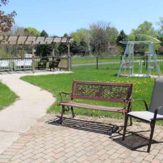 A peaceful outdoor area with a bench, pathway, and swing set.