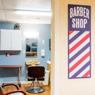Interior view of a barber shop with a sign and a styling chair.