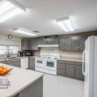 A modern kitchen with gray cabinets and various appliances.