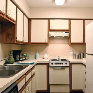A compact kitchen with beige cabinets and modern appliances.