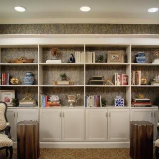 A well-organized living room with built-in bookshelves featuring various decorative items and books.