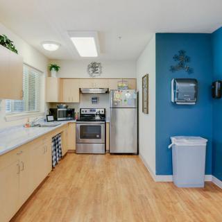 A modern kitchen with stainless steel appliances and a blue accent wall.