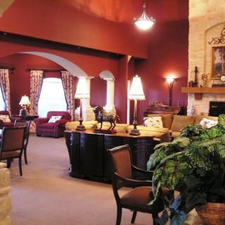 A cozy living room with warm colors, featuring comfortable seating, decorative lamps, and a fireplace.