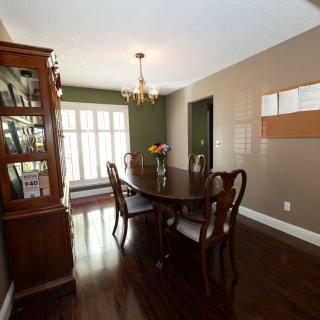 A classic dining room with a wooden table, chairs, and a chandelier above.