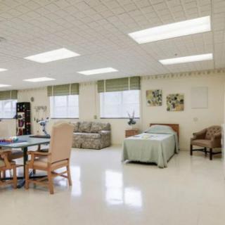A bright and spacious room with various furniture including a bed, chairs, sofa, and table.
