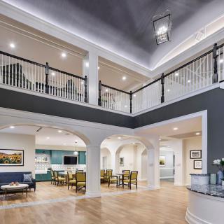 A spacious and modern interior featuring a dining area, balcony, and stylish lighting.