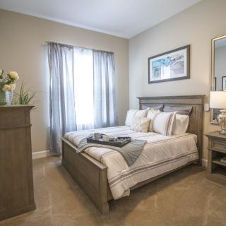 A cozy bedroom with a neatly made bed and soft lighting.