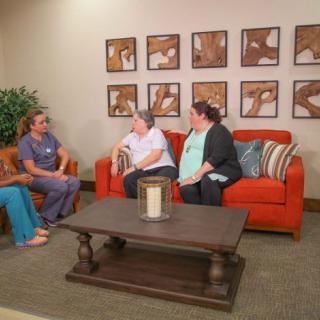 A group of people having a conversation in a cozy living room setting.