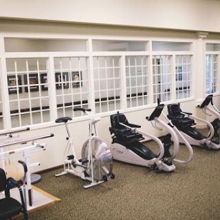 A well-equipped gym area featuring various exercise machines, ideal for fitness and rehabilitation.