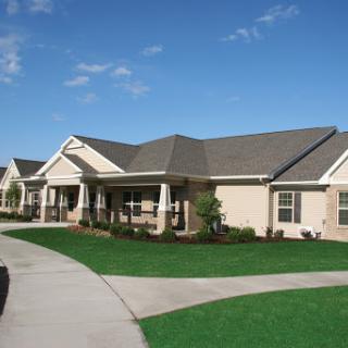 A picturesque view of suburban homes with well-maintained lawns and clear blue skies.