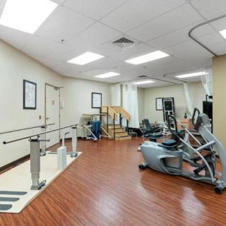 A rehabilitation room equipped with various exercise machines and therapy tools.