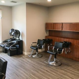 A well-organized barbershop featuring chairs and a hair washing station.