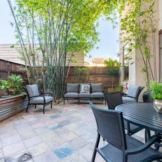 A cozy outdoor patio with seating and lush bamboo plants.