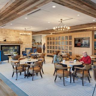 A cozy cafe interior with tables, chairs, and a fireplace creating a welcoming atmosphere.