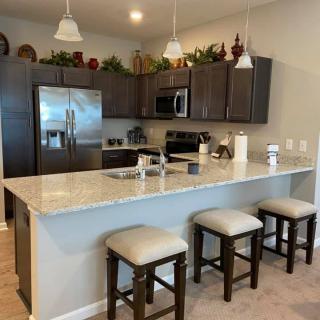 Modern kitchen with a large island, bar stools, and stainless steel appliances.