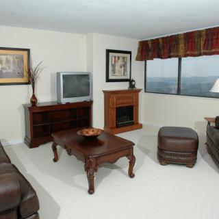 A cozy living room with a sofa, coffee table, TV, and fireplace.