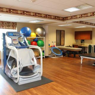 A therapy room equipped with exercise equipment and stability balls.