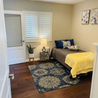 A cozy bedroom with a single bed, featuring a stylish rug and elegant decor.