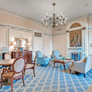 A luxurious, elegantly styled living room with a chandelier and classic furniture.