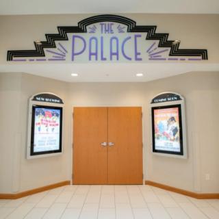 Art Deco-style entrance of The Palace cinema with movie posters on either side.