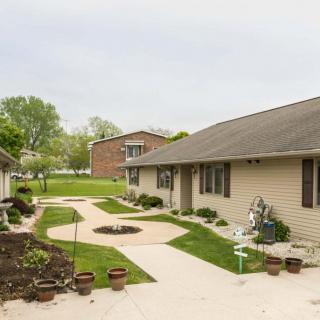 A view of residential houses with a well-maintained lawn and sidewalks.