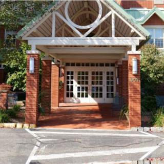 A charming entrance to a brick building with a decorative canopy.