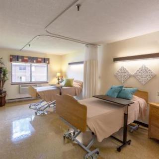 A well-lit patient room featuring two hospital beds, with a warm and inviting atmosphere.
