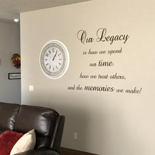 A cozy living room with a wall quote and clock.