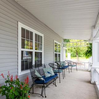 Inviting front porch with seating and greenery.