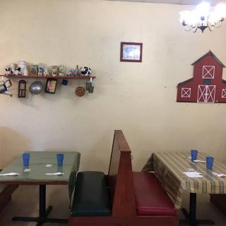 A cozy restaurant interior with farm-themed decorations and booth seating.