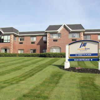 A well-maintained hotel exterior with landscaped grass in front.