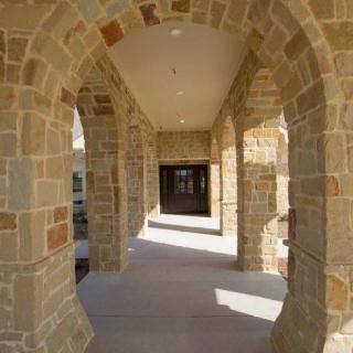 A stone archway corridor with columns and a covered walkway.