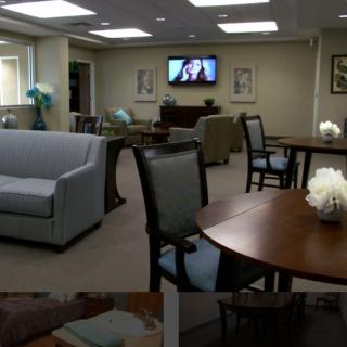 A cozy lounge area with sofas, tables, chairs, and a television on the wall.