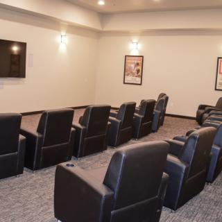 A cozy home theater with comfortable recliner seating and a large screen.