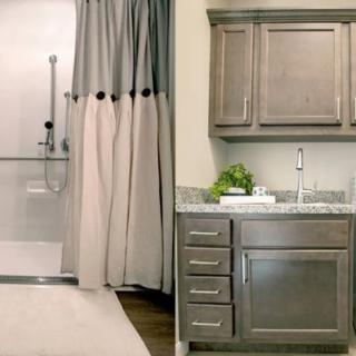A modern bathroom featuring a walk-in shower with a curtain and a vanity area with cabinetry and a sink.