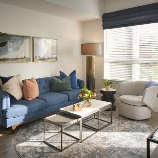 A modern living room with a blue sofa, stylish coffee table, and decorative accents.