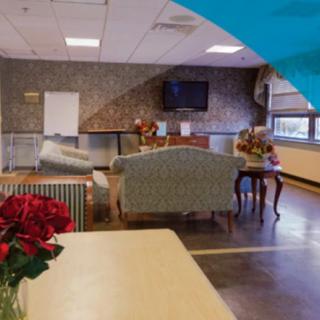 A cozy lounge area with sofas, a television, and a table decorated with flowers.